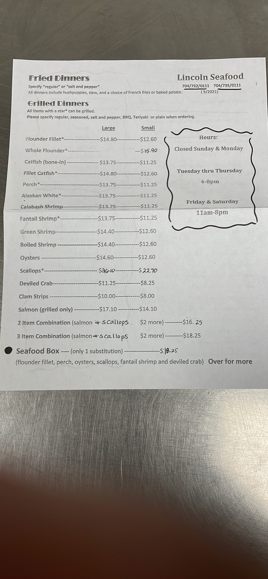 Menu board listing catfish, flounder, and scallops.